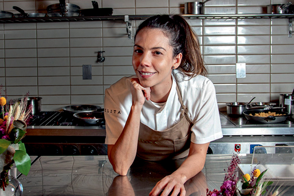 Retrato da chef Tássia Magalhães na cozinha de seu restaurante