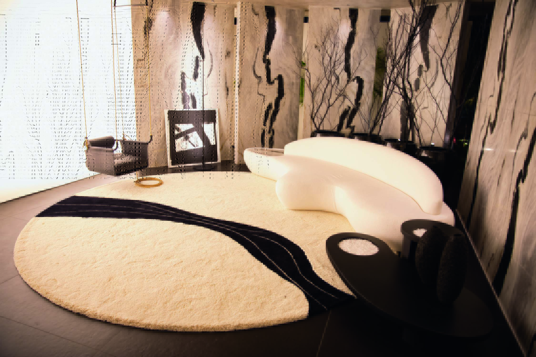 Imagem mostra sala branca e preta com carpete circular e poltrona branca