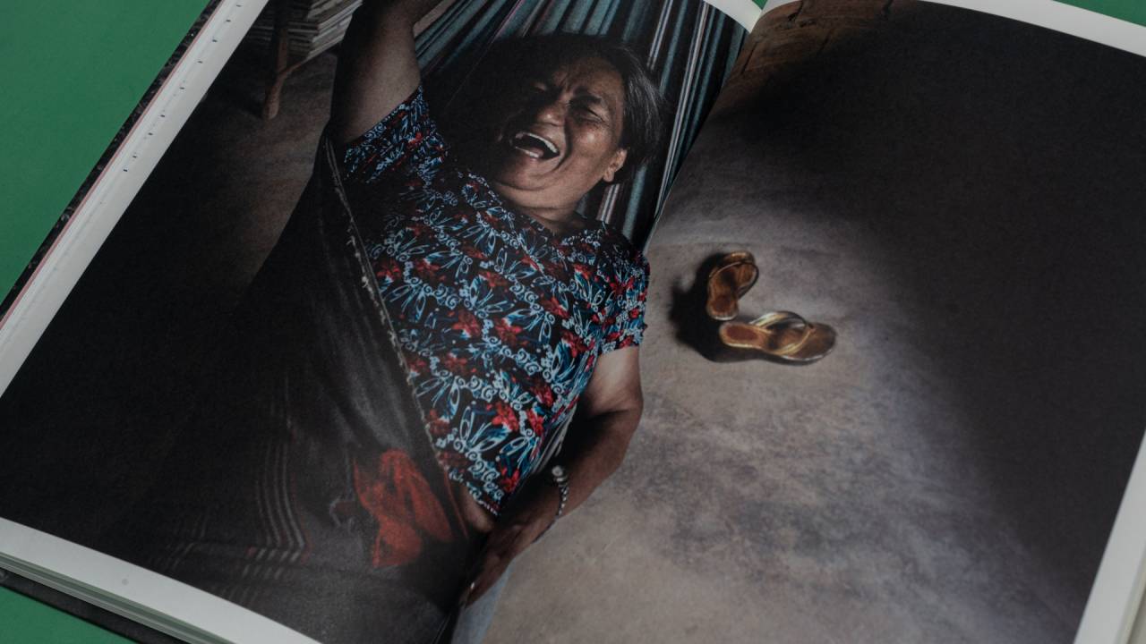 Imagem mostra página de fotolivro aberta, mostrando a imagem de uma senhora deitada em uma rede
