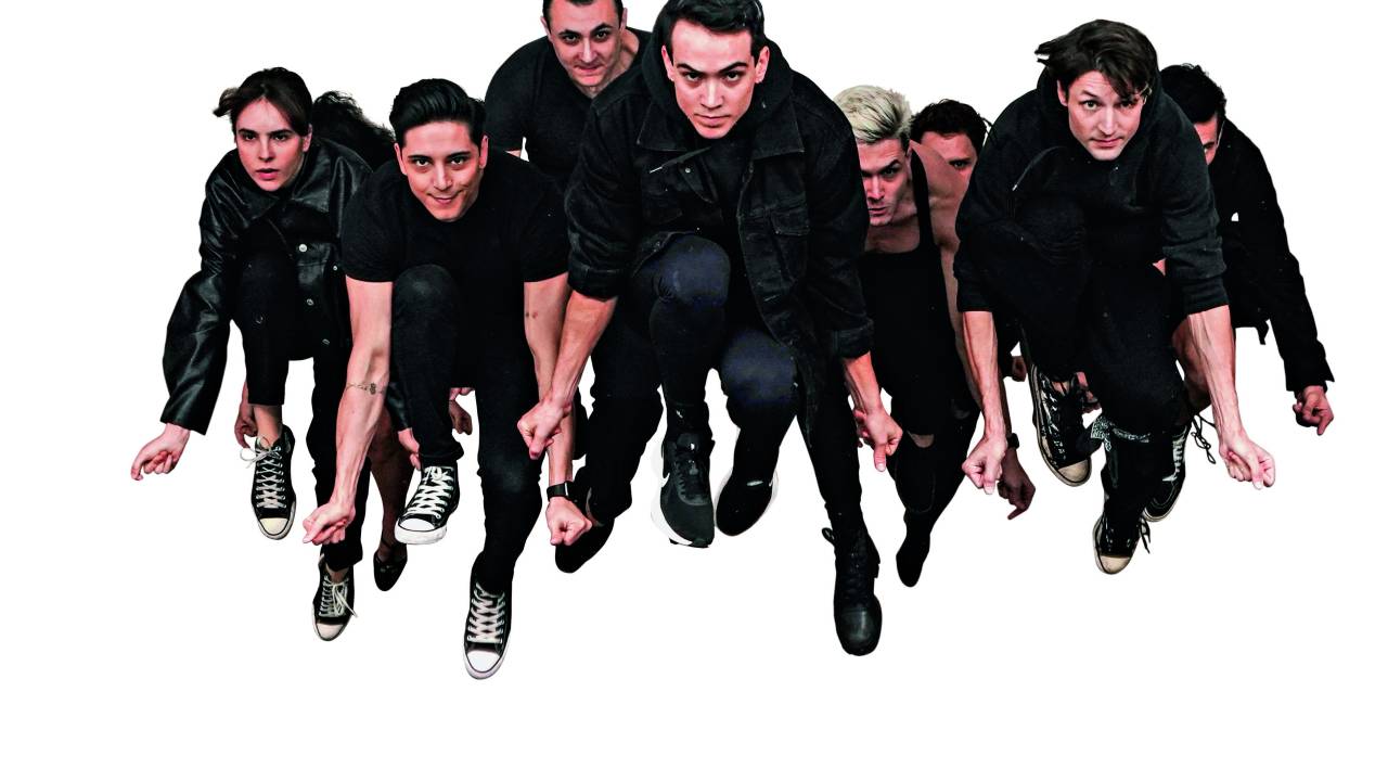 Imagem mostra elenco de pessoas pulando ao mesmo tempo, com os braços abaixados.