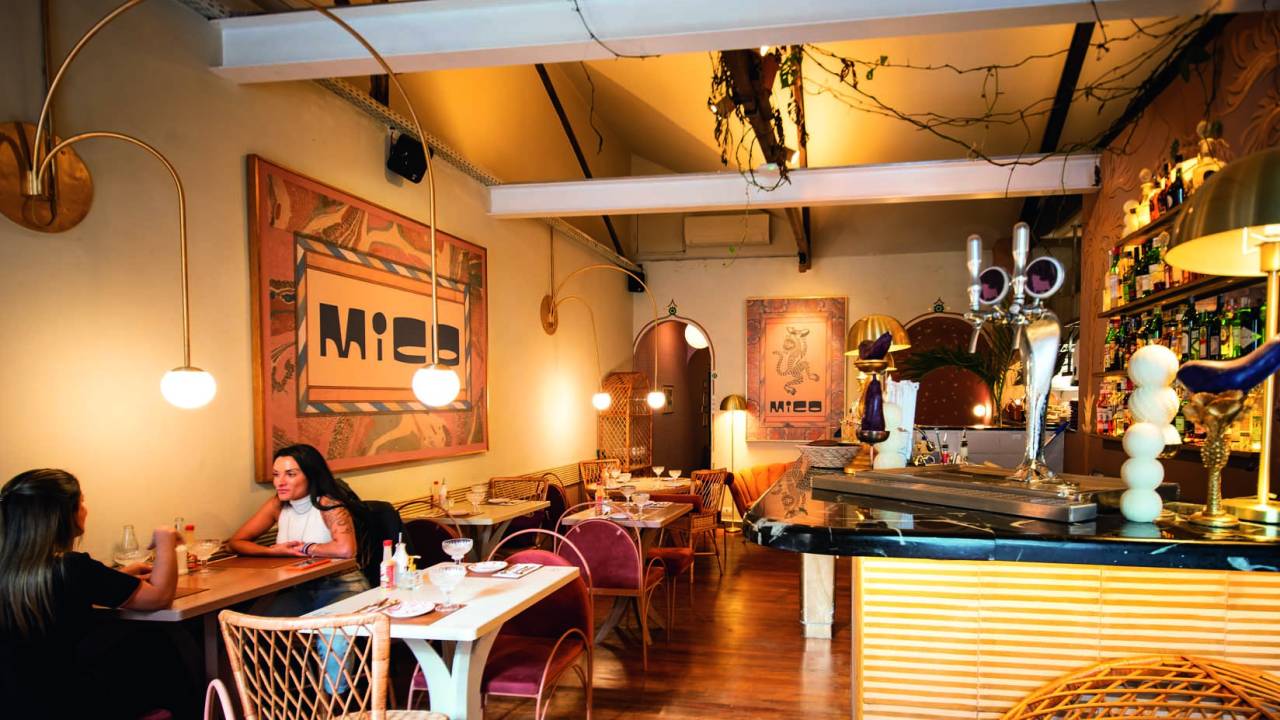 Vista do salão, mesas e balcão do restaurante Mico
