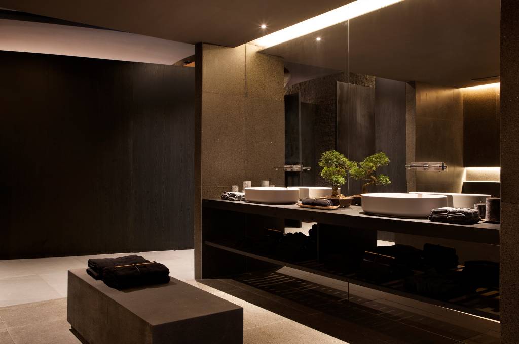 Banheiro com revestimentos em madeira; metais pretos