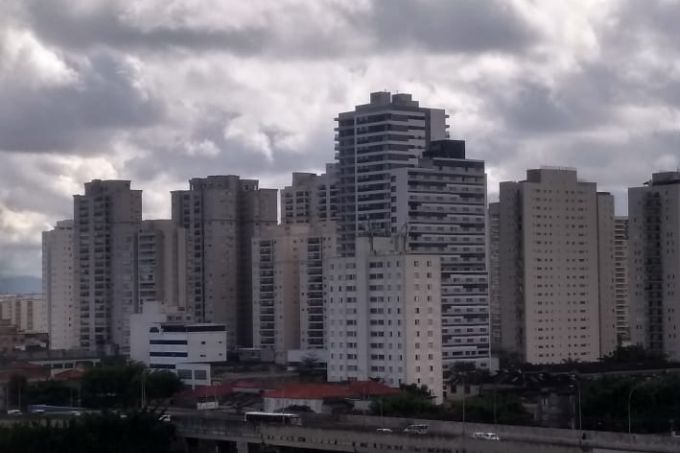 Imagem mostra paisagem com prédios em São Paulo e céu nublado