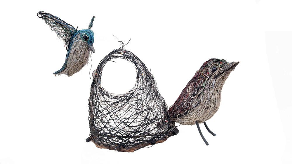 Esculturas de dois pássaros e um ninho feitas com cabos elétricos