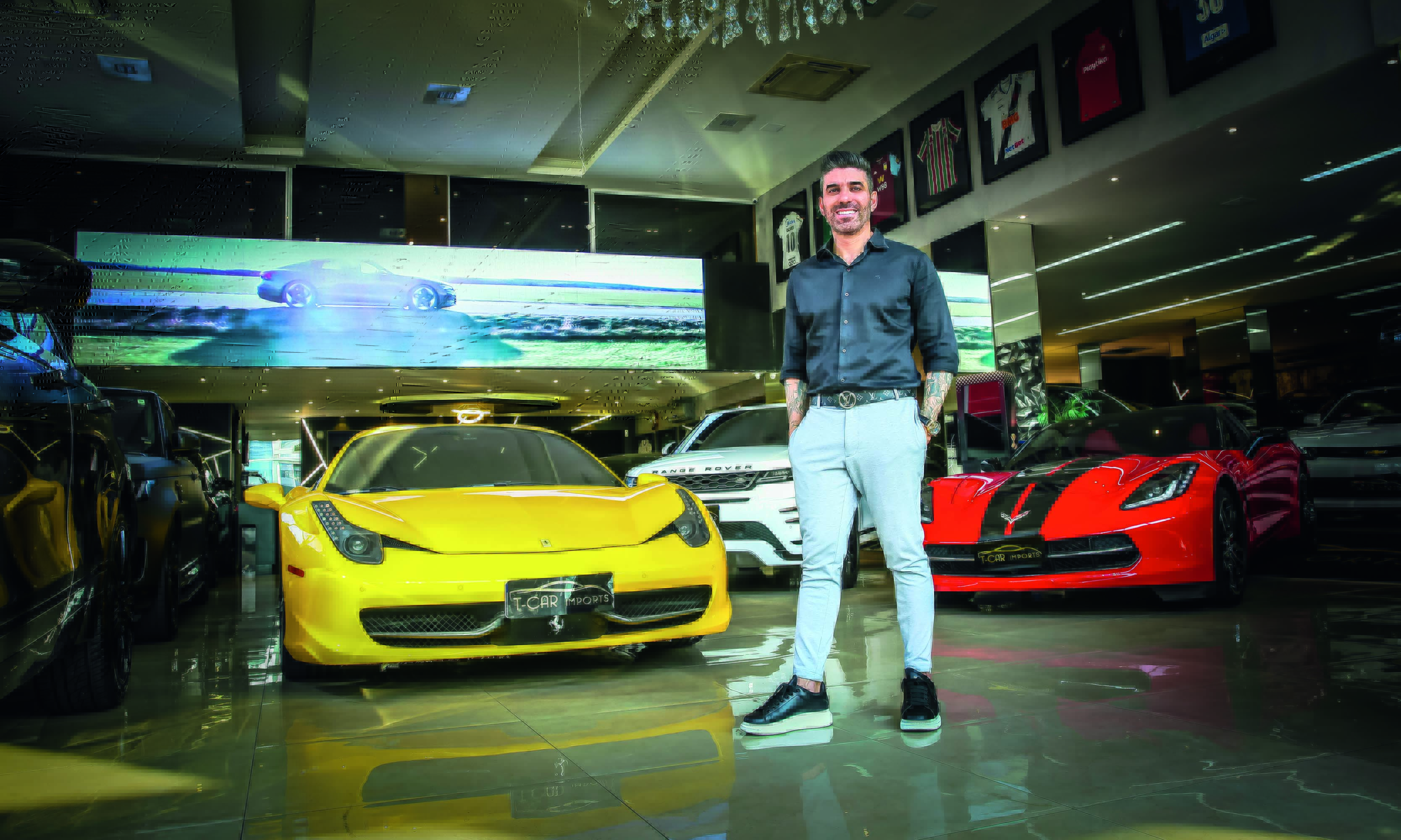 Imagem mostra homem em salão com diversos carros de luxo, brancos, amarelos e vermelhos