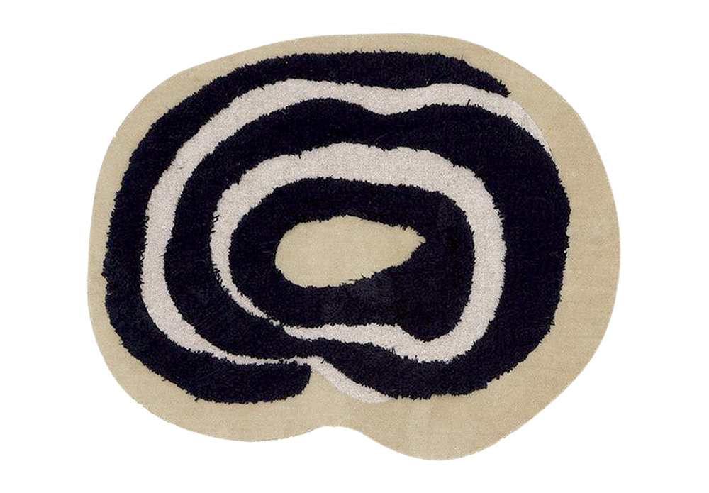 Tapete com formato arredondado irregular, com listras pretas e brancas em círculos e fundo bege