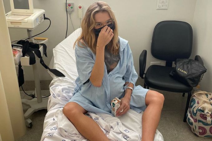 Isa Scherer sentada com roupa de hospital