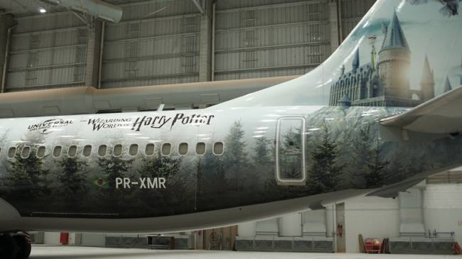 Traseira do avião tem adesivo com letreiro de Harry Potter, árvores e Castelo de Hogwarts