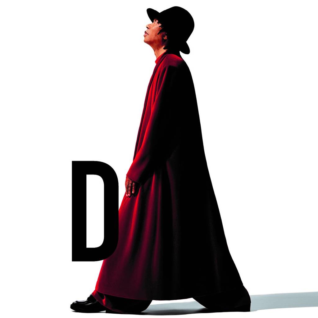 Djavan Capa Imagem mostra homem com roupão vermelho e chapéu caminhando. Ao seu lado esquerdo, uma letra