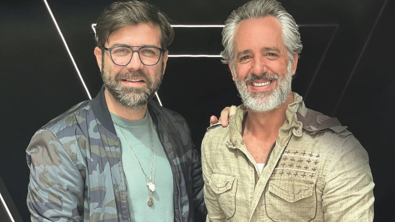 Fábio Maca e Ike Levy posam lado a lado. À esquerda, com óculos de grau, barba cinza, jaqueta e camiseta verde. À direita, grisalho de barba com camisa clara.