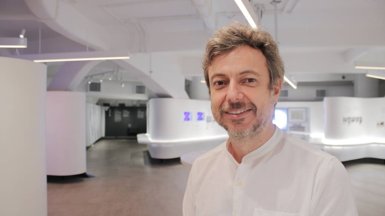 Felipe Arruda, diretor do Museu Judaico, sorri em retrato com camisa branca.