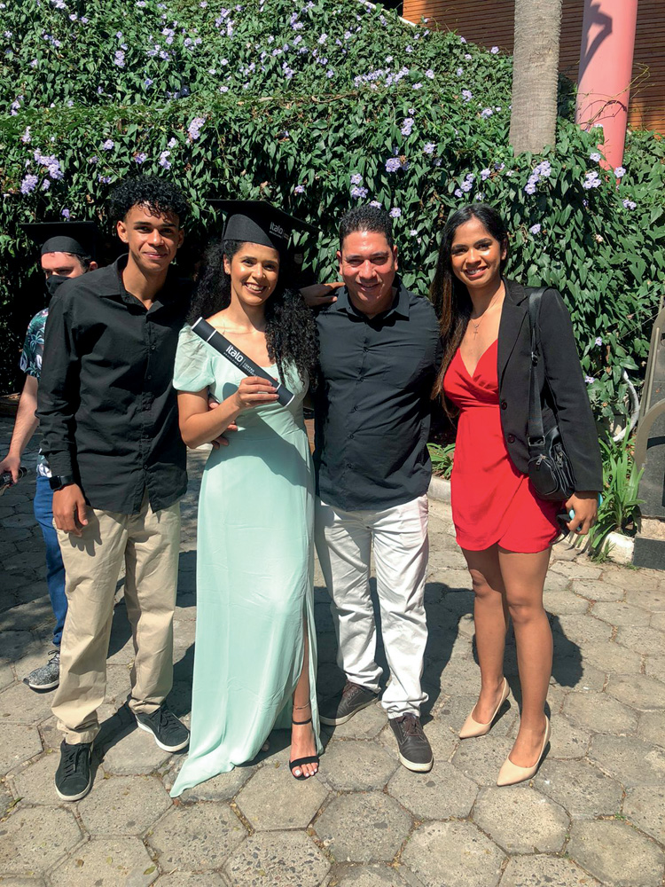 Flávia Rodrigues segura seu diploma em Marketing ao lado de três irmãos