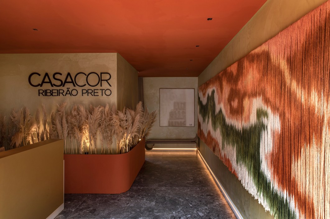 Gabriela Lemos Arquitetura - Fachada Future Design. Com a missão de desconectar o visitante da vida lá fora e inseri-lo na atmosfera da mostra, a arquiteta aposta na diversidade de formas, cores, materiais e texturas. A preferência é pelo uso de linhas retas. A exceção é a parede curva, já existente, coberta com lastras que reproduzem pedra italiana. Além dela, também chamam a atenção as telhas metálicas que reforçam o colorido da fachada – o perfeito mix entre tons neutros e fortes marca o lançamento da linha 2023 da Coral. O paisagismo, outro ponto alto do projeto, valoriza a arquitetura e cria espaços surpreendentes, que transmitem aconchego e conectam com a natureza. Gabriela Lemos Arquitetura - Fachada Future Design. Com a missão de desconectar o visitante da vida lá fora e inseri-lo na atmosfera da mostra, a arquiteta aposta na diversidade de formas, cores, materiais e texturas. A preferência é pelo uso de linhas retas. A exceção é a parede curva, já existente, coberta com lastras que reproduzem pedra italiana. Além dela, também chamam a atenção as telhas metálicas que reforçam o colorido da fachada – o perfeito mix entre tons neutros e fortes marca o lançamento da linha 2023 da Coral. O paisagismo, outro ponto alto do projeto, valoriza a arquitetura e cria espaços surpreendentes, que transmitem aconchego e conectam com a natureza.