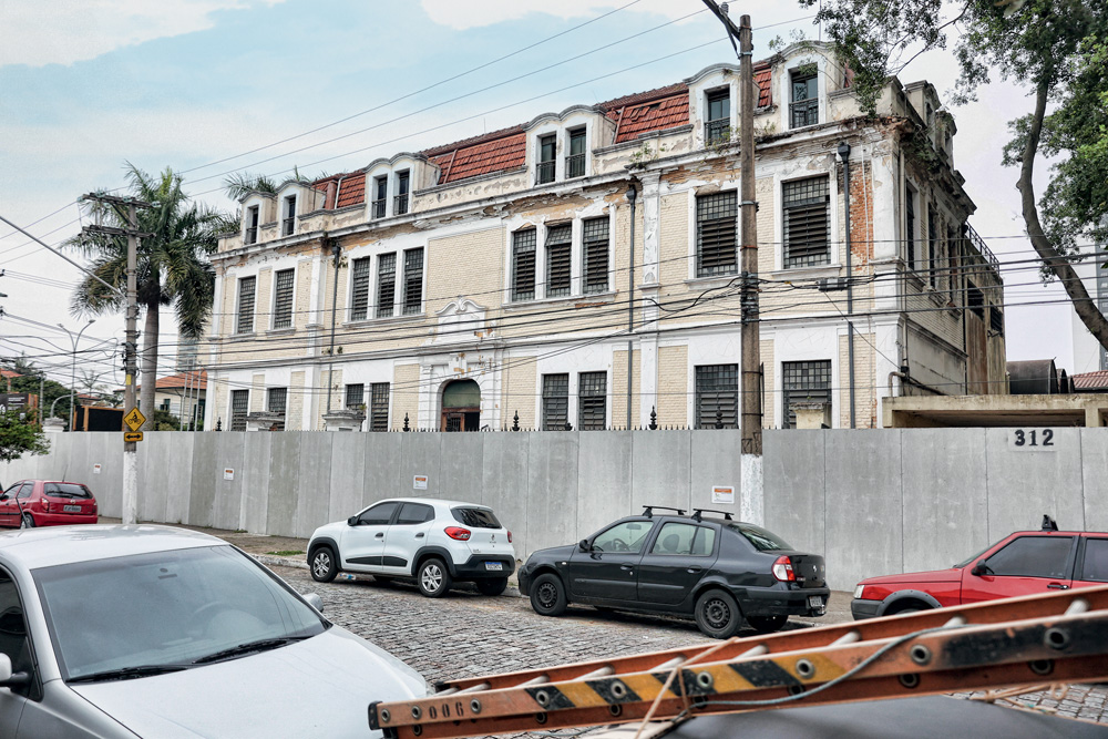 Imagem mostra fachada de colégio sendo restaurado.