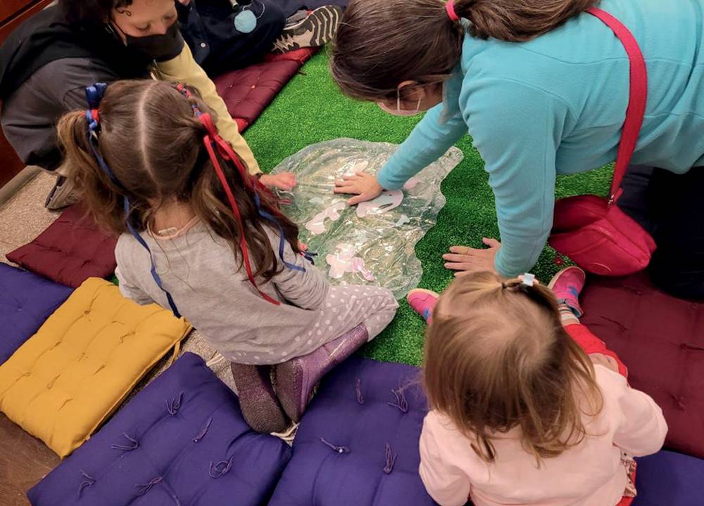 Crianças vistas de cima brincando em tapete colorido