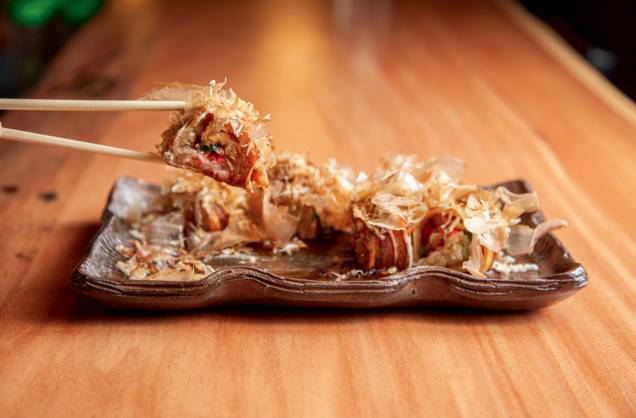 Takoyaki: bolinho de polvo feito na chapa, com gengibre em conserva e, lascas de tempurá