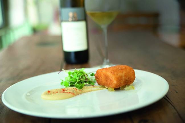 Baccalà, ceci e cedri canditi_2_Johnny Mazzilli.jpg Prato branco raso contendo bacalhau, grão de bico e cidra cristalizado, com uma garrafa de vinho tinto ao fundo