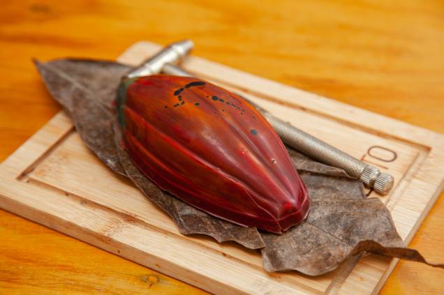 Cacauaçu: casquinha de chocolate no formato de cacau recheada com musse de cupuaçu assentada numa lâmina de brownie