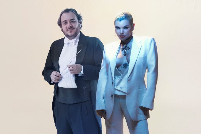 Foto de Rodrigo Toffolo e Duda Beat usando ternos, diante de fundo branco