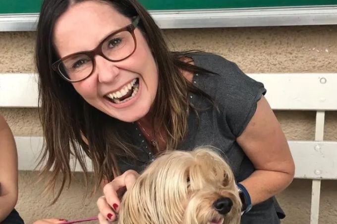 Foto de Susana Naspolini sorrindo, com um cachorro no colo