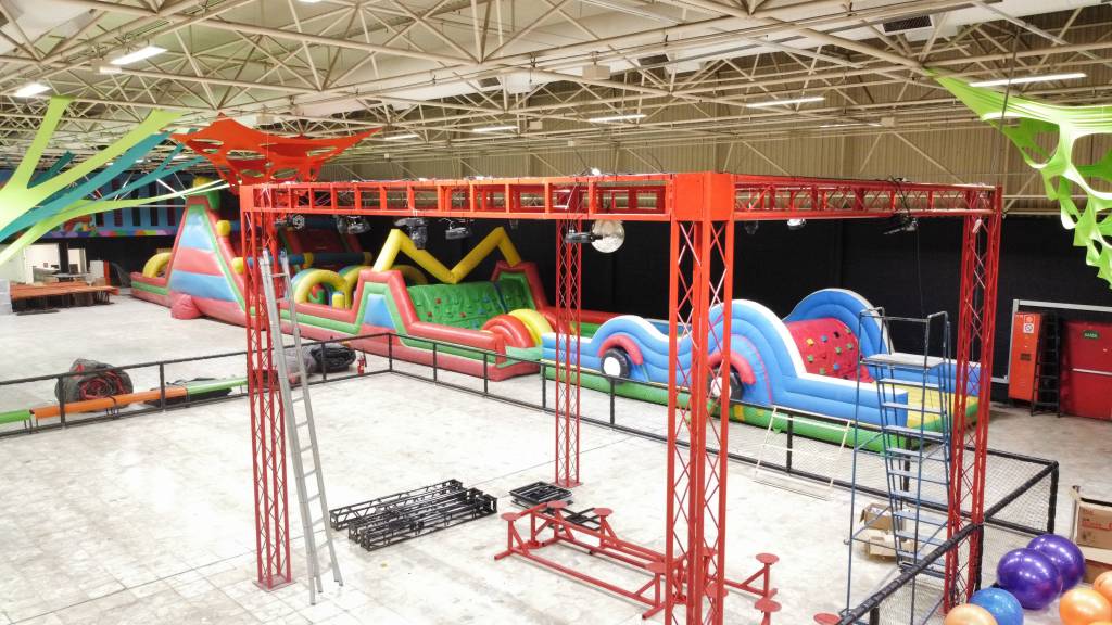 Foto de parque indoor com estruturas inacabadas e um grande brinquedo inflável e colorido ao fundo