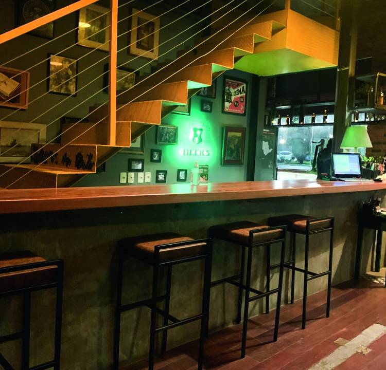 Ambiente interno Ipo Bar com balcão bancada e escada atrás