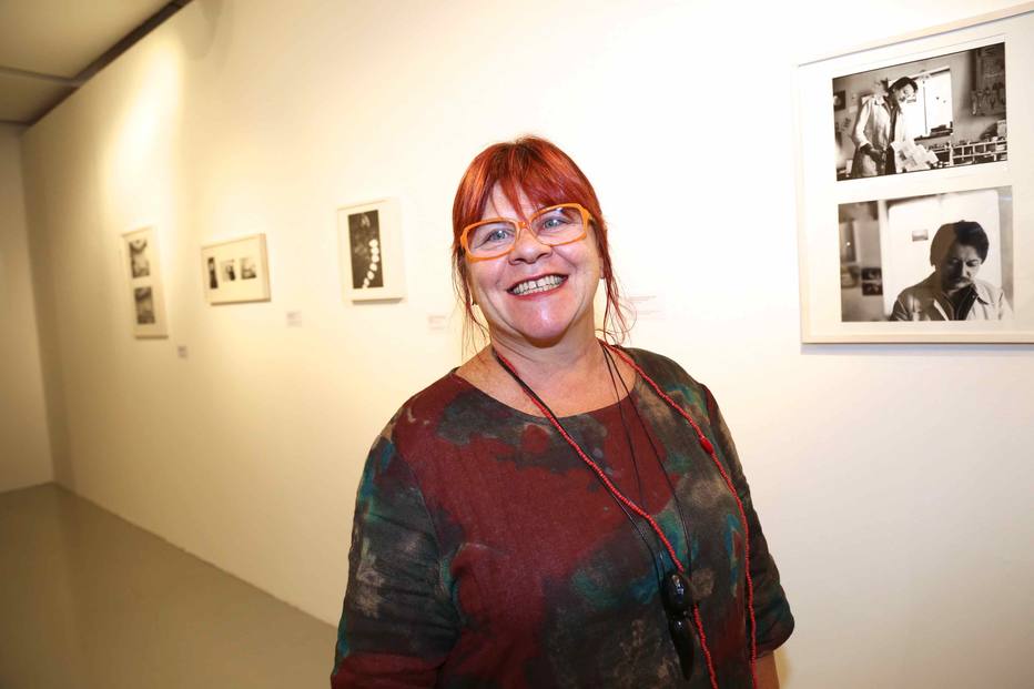 A artista Rochelle Costi sorri em um museu