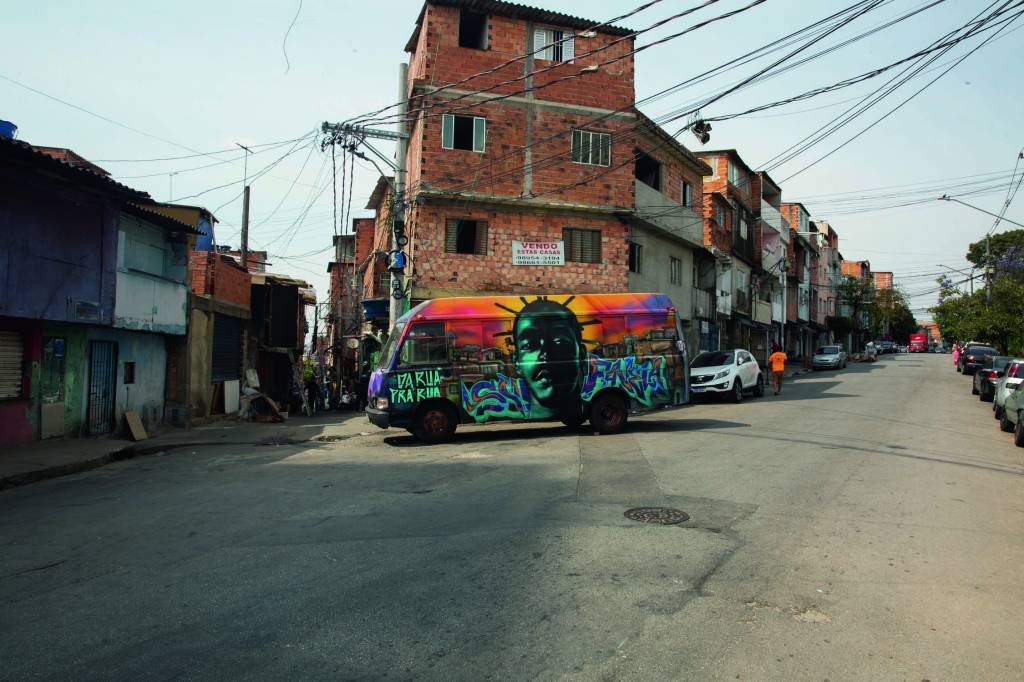 Imagem mostra ônibus grafitado em esquina de comunidade