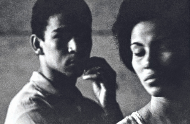 Imagem em preto e branco mostra um homem olhando para uma mulher