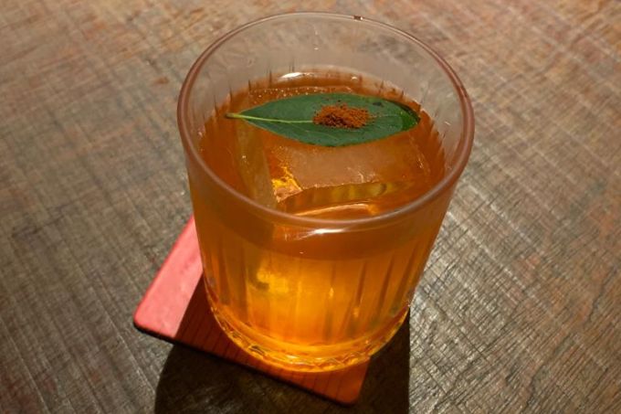 Drinque Sotaque: uma mistura de cachaça, uísque, bitter e Aperol saborizado com pimentão tostado, pimenta biquinho e coentro.