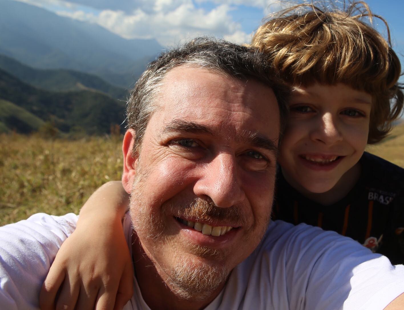 Imagem mostra homem sorrindo ao lado de crian&ccedil;a