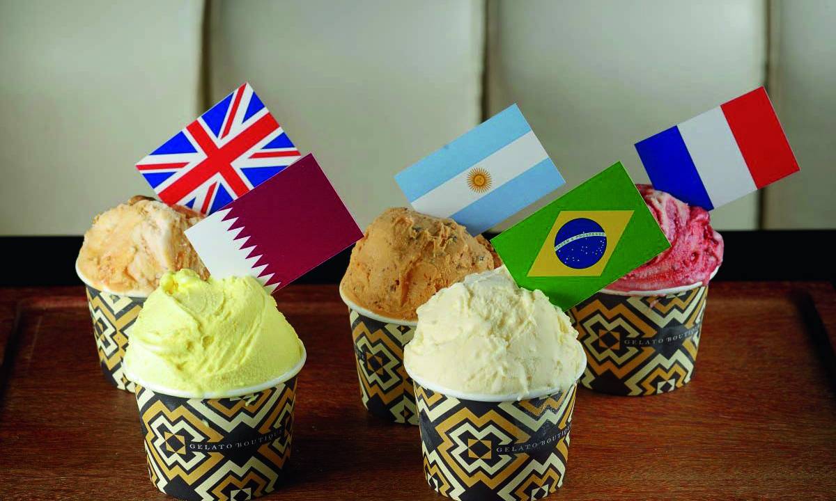 Quatro copinhos de sorvete com sorvetes diferentes e as bandeiras da Inglaterra, Brasil, Argentina, França e Catar