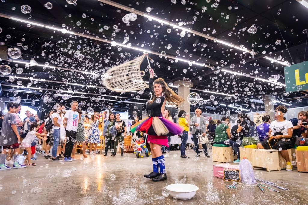 Foto de menina em meio a espaço com bolhas de sabão