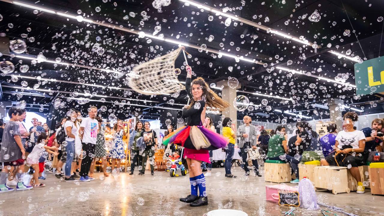 Foto de menina em meio a espaço com bolhas de sabão