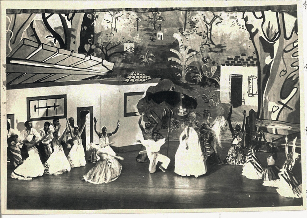 Imagem em preto e branco mostra grupo de teatro de pessoas pretas se apresentando no palco do Municipal
