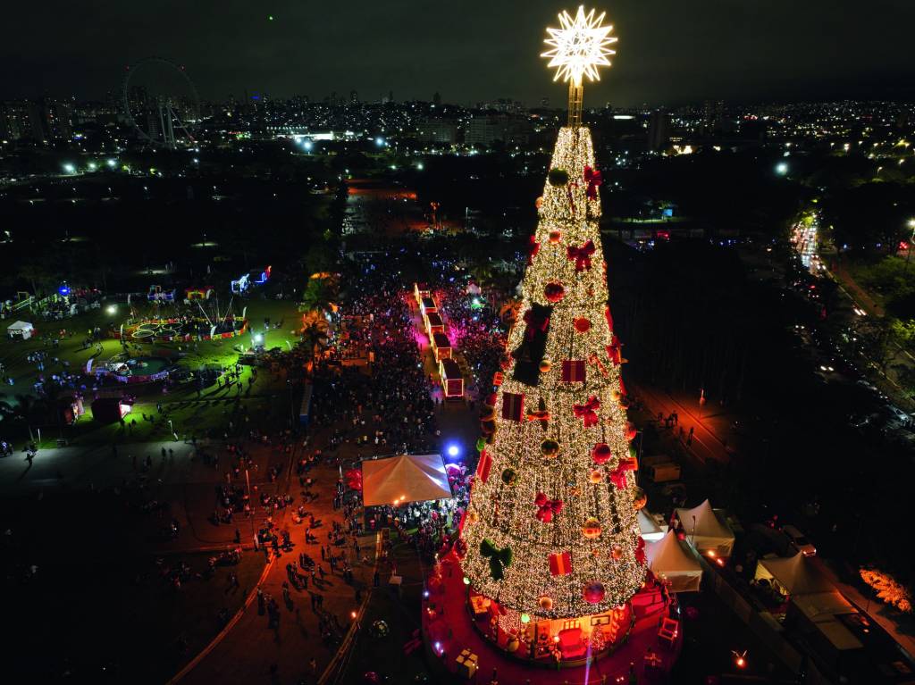 Foto aérea mostra árvore de Natal e fileira de caminhões saindo em direção a rua