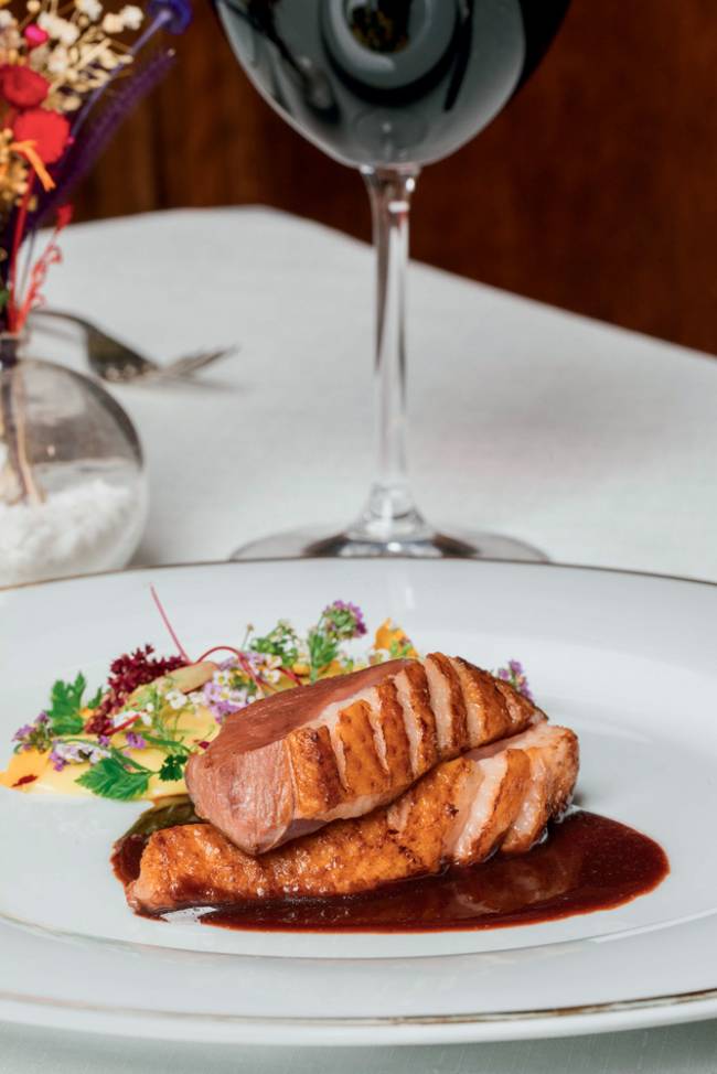 La Casserole Magret peito de pato Peito de pato ao molho de cereja em prato de porcelana branca