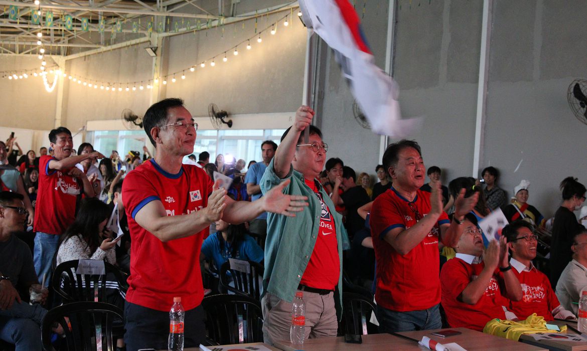 Torcedores com camisa da Coreia do Sul levantam bandeiras