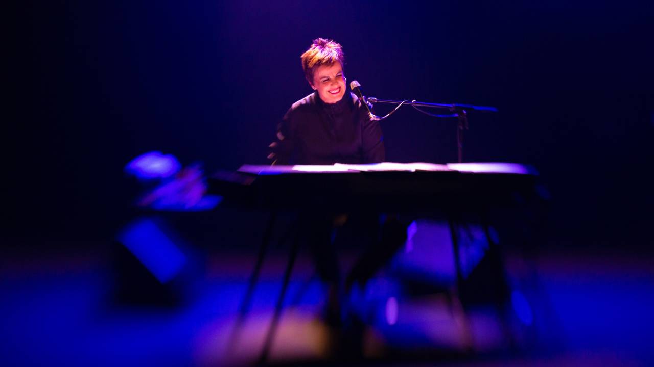 Imagem mostra mulher tocando piano, sorrindo