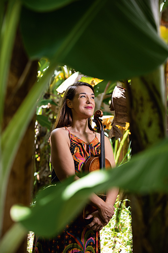 Imagem mostra mulher sorrindo em meio a plantas