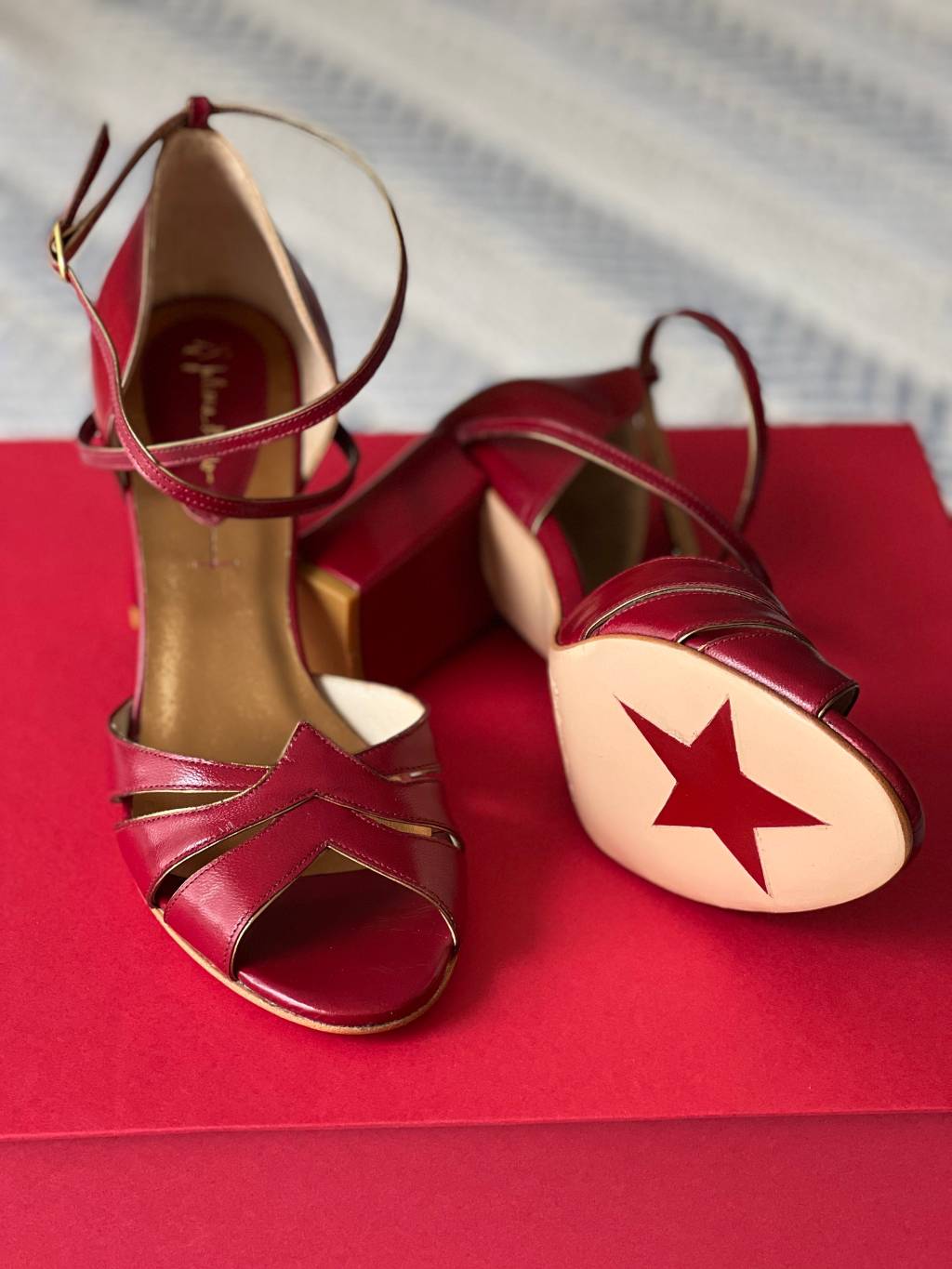 Sapatos vermelhos de salto alto exibem estrela na sola.