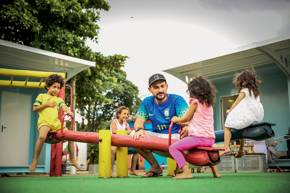 Eduardo Severino Silvestre da Silva (de boné) brinca com as filhas no playground