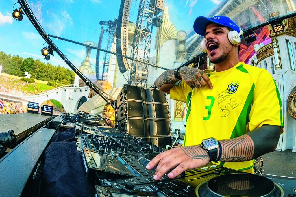 Imagem mostra DJ com camisa do Brasil tocando em palco