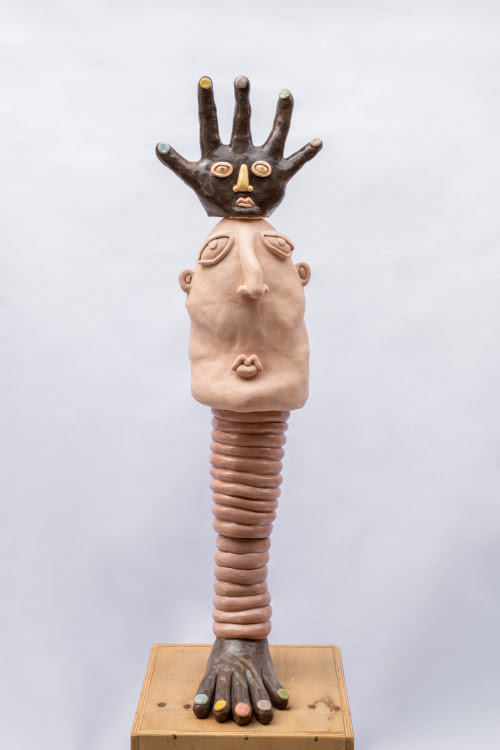 Estrambote Bruna Gidi Salão Artistas sem Galeria 2023 Zipper Escultura em cerâmica em forma de totem com um pé negro na base, um pilar anelado, um rosto branco e uma mão negra no topo