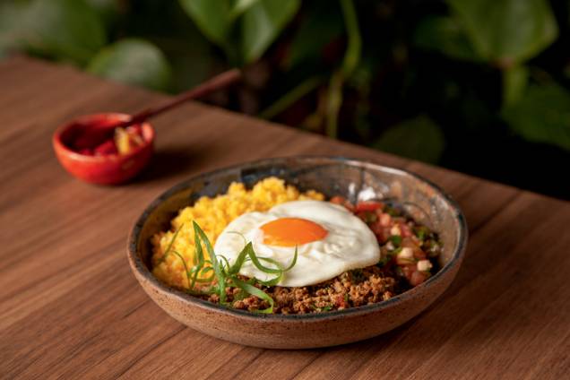 Baixaria: cuscuz de milho, carne moída, salada de tomate, cebolinha e ovo frito de gema mole,