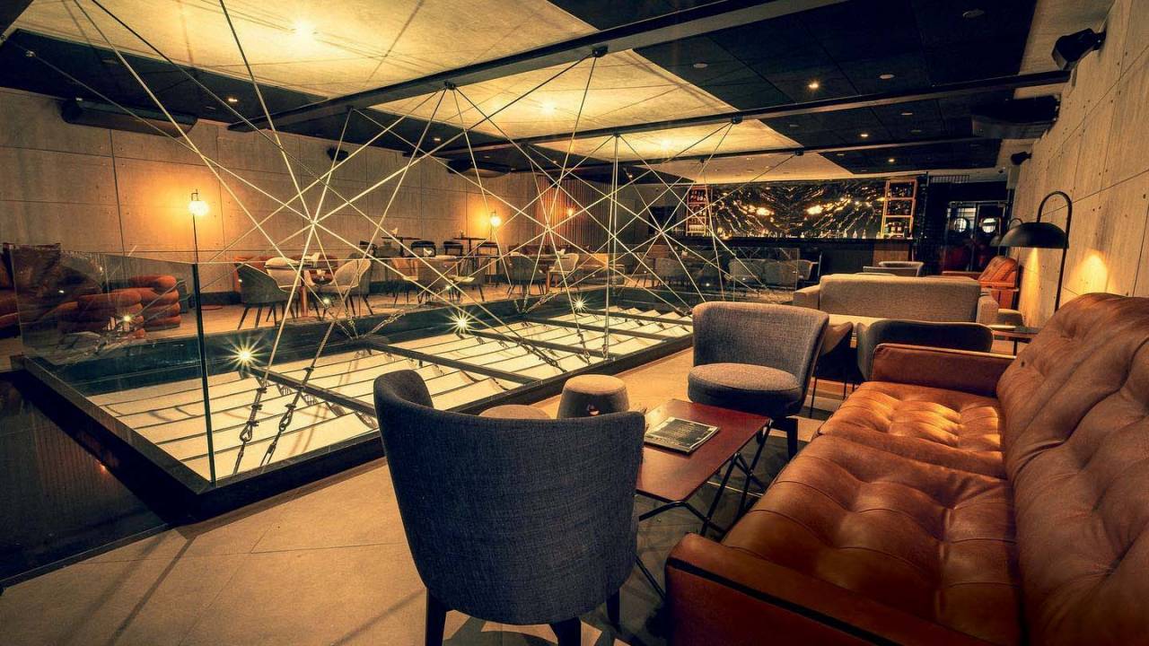 Ambiente de bar com luz baixa e poltronas de couro
