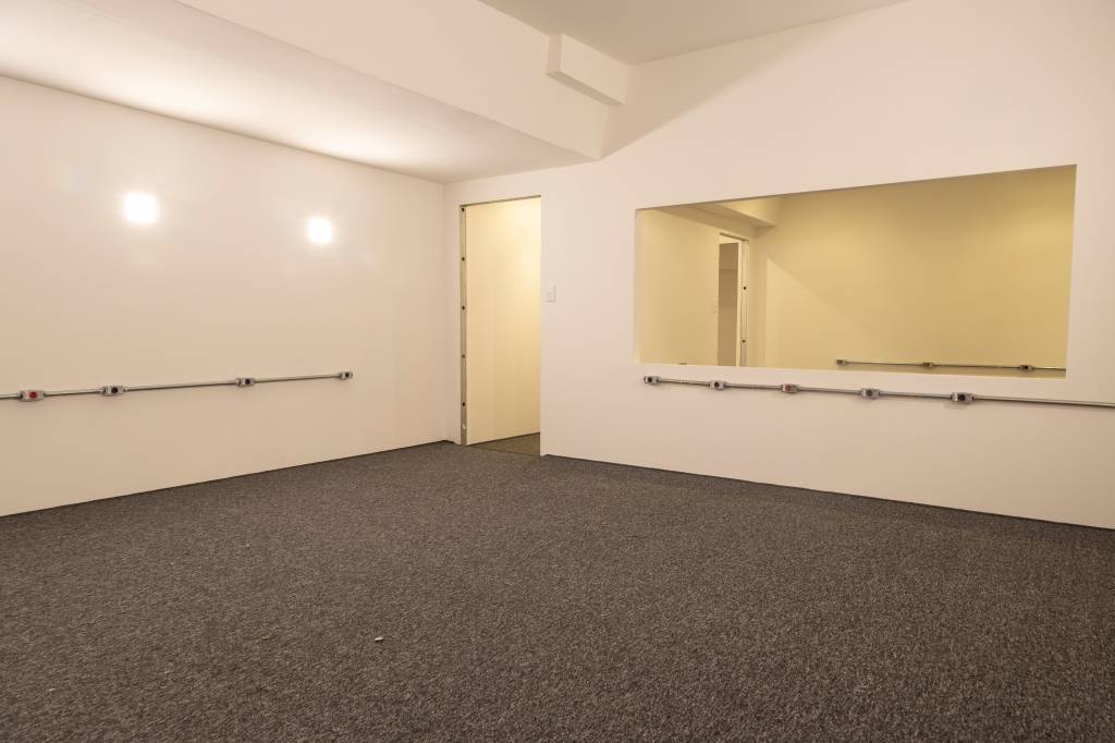 Sala com carpete cinza e paredes brancas
