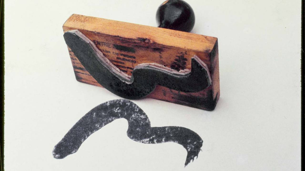 Imagem mostra carimbo com tinta preta, em formato ondulado
