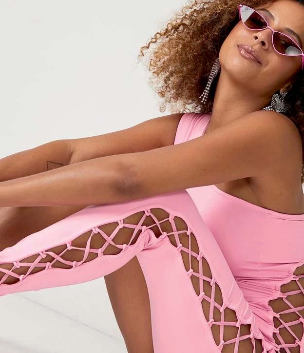 Modelo negra e magra usa macac&atilde;o rosa claro de malha com ombro e perna &uacute;nica