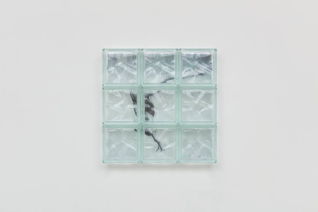 Imagem mostra obra de arte com tijolos de vidro sobre foto de nadadora pulando em piscina